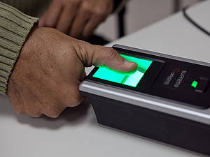 Dedo de eleitor sobre coletor biométrico